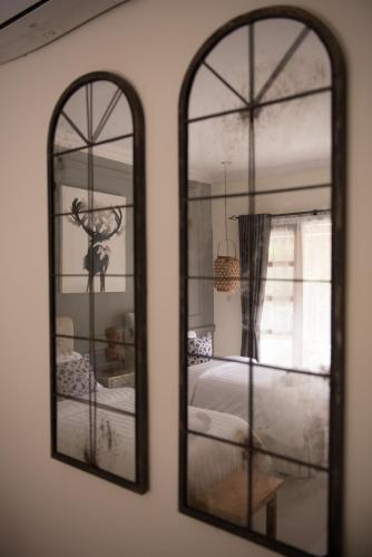 a mirror reflecting a bedroom with a bed and a window at Blue Garden Yogyakarta in Yogyakarta