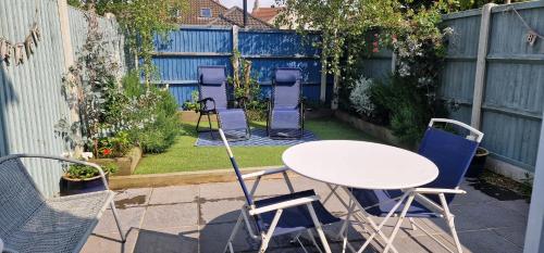 a table and chairs in a backyard with a fence at Avocet - Suffolk Coastal Escapes in Pakefield