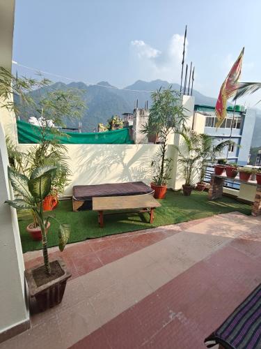 a bench sitting on top of a balcony with plants at Mild Life Hostel Rishikesh in Rishīkesh