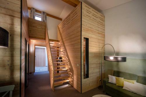 a wooden staircase in a room with a green couch at Hotel Lindenwirt in Drachselsried