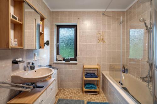 un baño con lavabo y bañera en 2-Zimmer Ferienwohnung Am Waldrand, en Schönwald