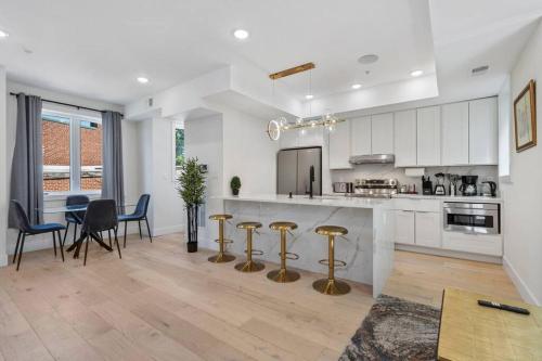 a kitchen with white cabinets and gold bar stools at Capitol Hill 4 Charming Townhouse in Downtown DC with Rooftop Free Parking and WIFI in Washington, D.C.