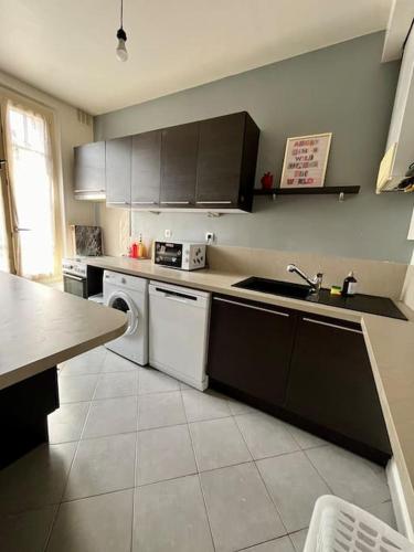 une cuisine avec un évier et un lave-vaisselle dans l'établissement F2 parking Gare, à Melun