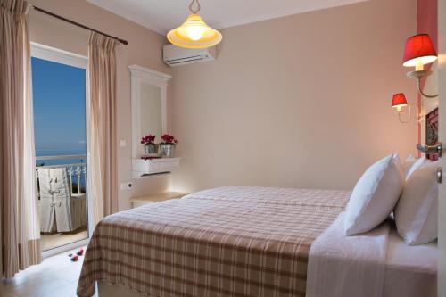 a bedroom with a bed with a view of the ocean at Amalia Apartments in Exanthia