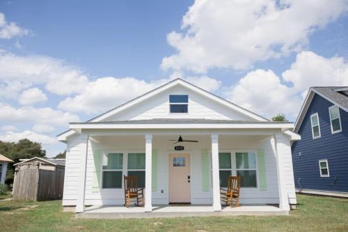 a small white house with two chairs in front of it at Dorothy in Gulfport