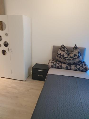 a bedroom with a bed with a pillow and a dresser at Pension Valentina in Mühlau