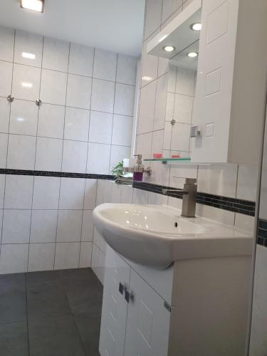 a white bathroom with a sink and a mirror at Pension Valentina in Mühlau