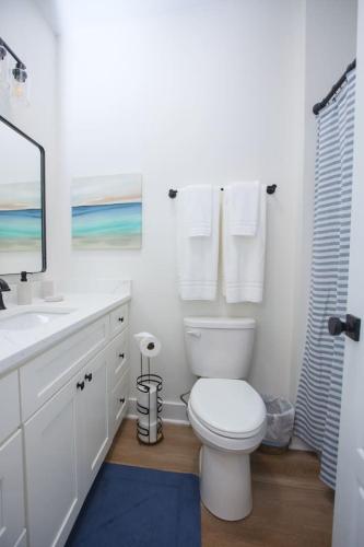 a white bathroom with a toilet and a sink at Dorothy in Gulfport