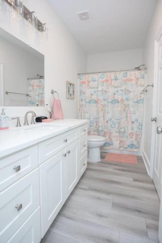 a white bathroom with a sink and a toilet at Bluebird By The Sea in Gulfport