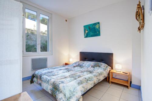 une chambre avec un lit et deux fenêtres dans l'établissement Mirande 1 - Appt vue mer et montagne, à Port-Vendres