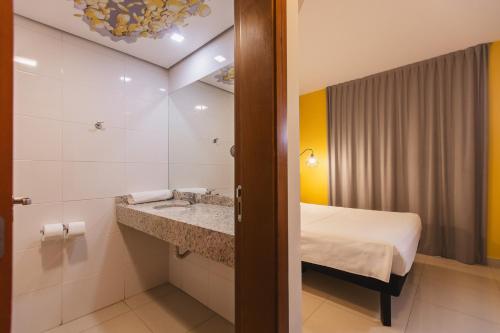 a hotel room with a bed and a sink at Hotel Euro Suite São Jose do Rio Preto by Nacional Inn in Sao Jose do Rio Preto
