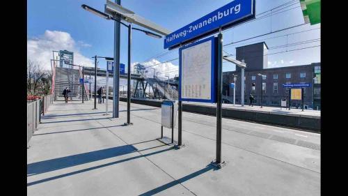 a bus stop with a sign at a train station at Nice Spacious House Near Amsterdam And Schiphol in Zwanenburg