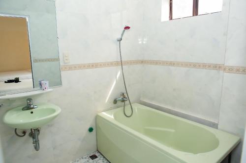 a bathroom with a sink and a bath tub and a mirror at Minh Hiếu Hotel in Hue