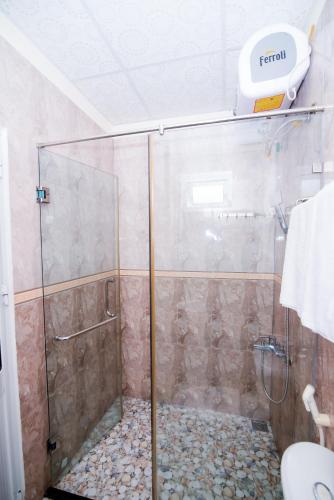 a shower with a glass door in a bathroom at Minh Hiếu Hotel in Hue