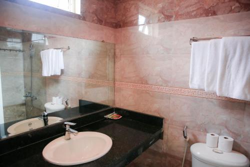 a bathroom with a sink and a toilet and a mirror at Minh Hiếu Hotel in Hue