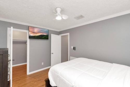 a bedroom with a white bed and a painting on the wall at Peaceful Waters Your Intimate Hot Tub Escape in Houston