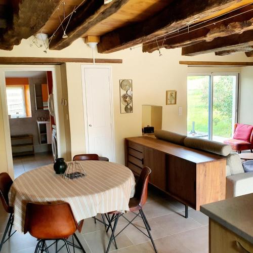 une cuisine et une salle à manger avec une table et des chaises dans l'établissement Gîte à la campagne, à Guidel