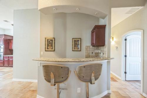 a kitchen with two bar stools at a counter at 438 Indoor Pool with a Theater Room in Homestead Meadows South