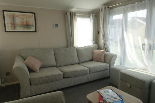 a living room with a couch and a window at Red Lion Holiday Park in Arbroath