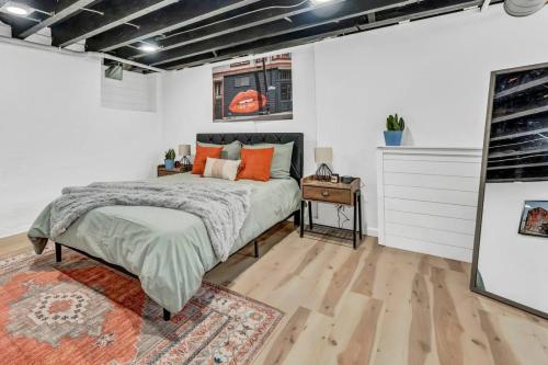 a bedroom with a bed with orange pillows on it at Tasteful Full Home Dtown Buffalo in Buffalo