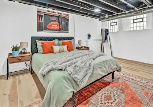 a bedroom with a large bed with orange pillows at Tasteful Full Home Dtown Buffalo in Buffalo