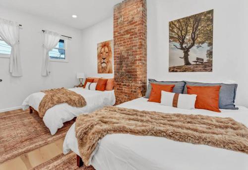 a bedroom with two beds and a brick wall at Tasteful Full Home Dtown Buffalo in Buffalo