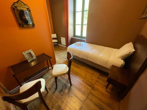 a small room with a bed and a table and a chair at Tavarn Ty Gar in Hennebont