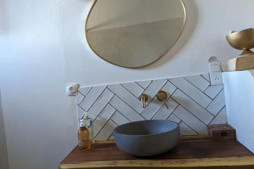 une salle de bain avec un lavabo et un miroir dans l'établissement Maison cosy et jardin, à Avignon