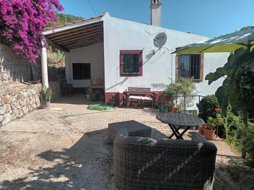 a small house with a table and a patio at Casa da Foía in Monchique