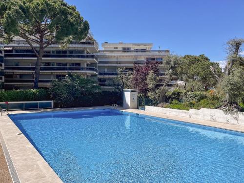 une grande piscine bleue devant un immeuble dans l'établissement Studio Cozy Juan les Pins Calme et Proximite, à Antibes