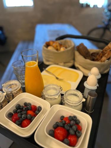 a table with a tray of food with fruit and cheese at Hof van Balloo in Balloo