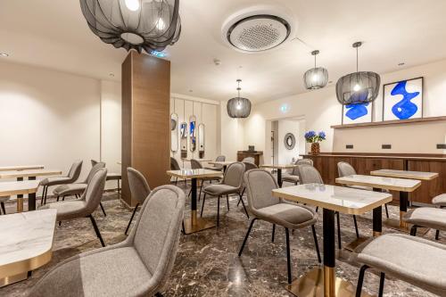 een restaurant met tafels en stoelen in een kamer bij Le Madame By Sweett in Parijs