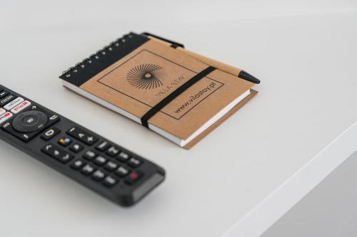 a remote control and a book next to a calculator at Villa Stay Luxury Property Ponte De Lima in Ponte de Lima