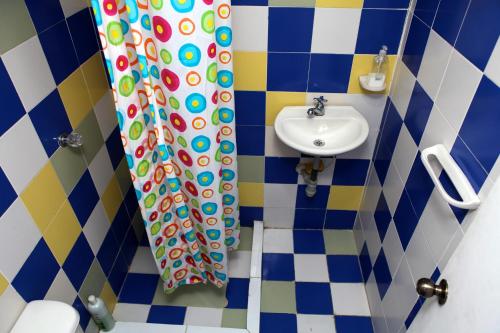 a bathroom with a shower curtain and a sink at Blue Almond Hostel - San Andres in San Andrés