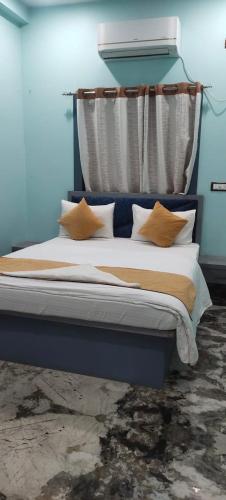 a blue bedroom with a bed with pillows at OASIS INN in Baharampur