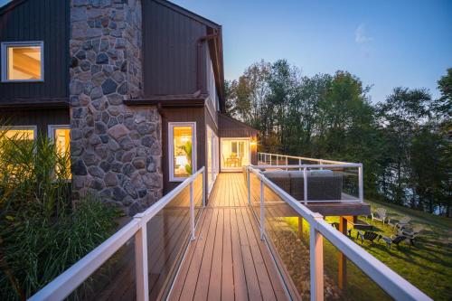 a wooden walkway leading to a house with a porch at MuskokaWaterfront PoolTable 98TV 6Acres in Huntsville