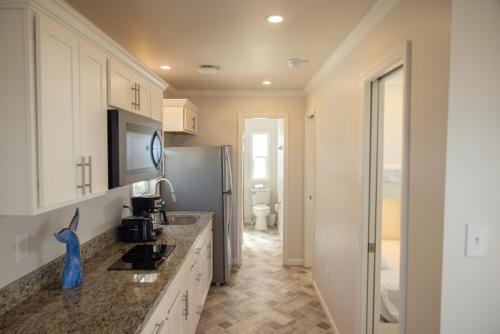 a kitchen with a sink and a refrigerator at Blufin Bungalows & Marina in Chincoteague