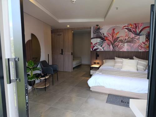 a bedroom with a large bed with a painting on the wall at Hotel Living 35 Suites in Medellín