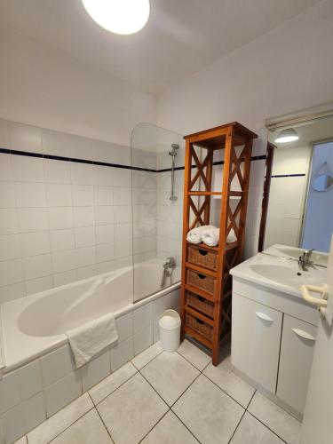 une salle de bain avec une baignoire et un lavabo dans l'établissement Appartement fonctionnel hauteurs de Collioure, à Collioure