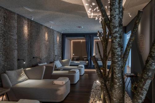 a living room with couches and chairs and trees at Hotel Lindenwirt in Drachselsried
