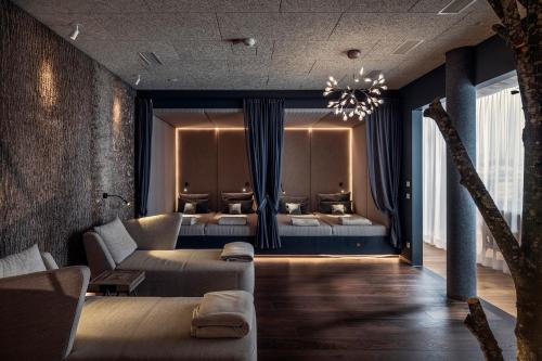 a hotel room with two beds and a couch at Hotel Lindenwirt in Drachselsried