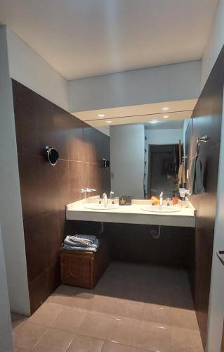 a bathroom with a sink and a large mirror at DUPLEX mc in Posadas