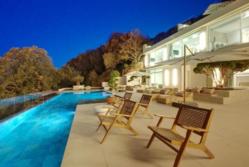 un patio avec des chaises et une piscine dans l'établissement Villa Tigliola, à Porto-Vecchio