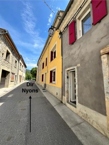 Une rue vide avec un panneau indiquant le creux des nyons dans l'établissement Charmant gite esprit chalet, à Saint-Nazaire-le-Désert