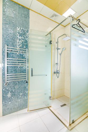 a shower with a glass door in a bathroom at Little Gem in the Old City - One Bedroom in Baku