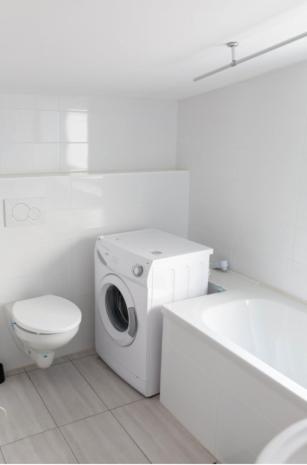 a white bathroom with a toilet and a washing machine at Zentrales Wohnhaus Ichenhausen in Ichenhausen