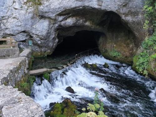 a tunnel in a rock wall with water rushing through it at 3 pièces spacieux plein centre, parking,clim, terrasse, jardin in Foix