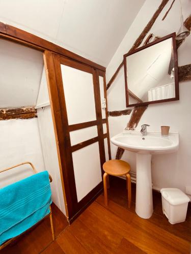 a bathroom with a sink and a stool and a mirror at Longère de charme familiale pour un WE au coin du feu Joli hameau, calme, cheminée in Esches