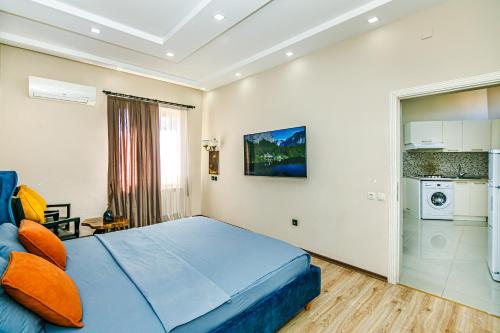 a bedroom with a blue bed and a kitchen at Little Gem in the Old City - One Bedroom in Baku
