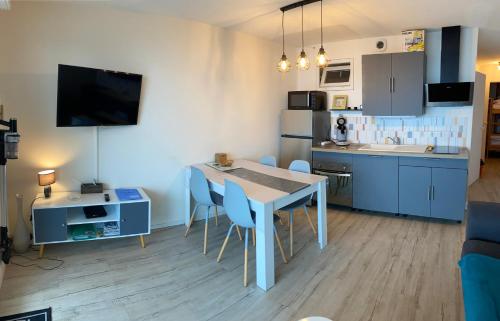 une cuisine et une salle à manger avec une table et des chaises dans l'établissement Appartement 4 personnes- 2 chambres face à l océan saint hilaire de riez, à Saint-Hilaire-de-Riez